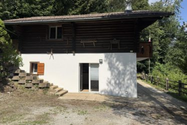 Chalet en rondins d’épicéa dans un écrin de verdure, avec vue sur la plaine du Rhône