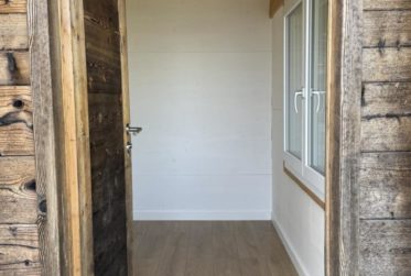 Chalet en rondins d’épicéa dans un écrin de verdure, avec vue sur la plaine du Rhône