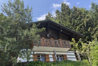 Chalet en rondins d’épicéa dans un écrin de verdure, avec vue sur la plaine du Rhône