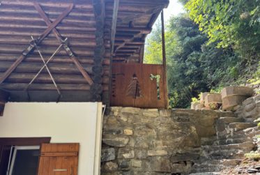 Chalet en rondins d’épicéa dans un écrin de verdure, avec vue sur la plaine du Rhône