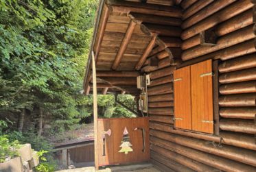 Chalet en rondins d’épicéa dans un écrin de verdure, avec vue sur la plaine du Rhône