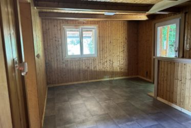 Chalet en rondins d’épicéa dans un écrin de verdure, avec vue sur la plaine du Rhône